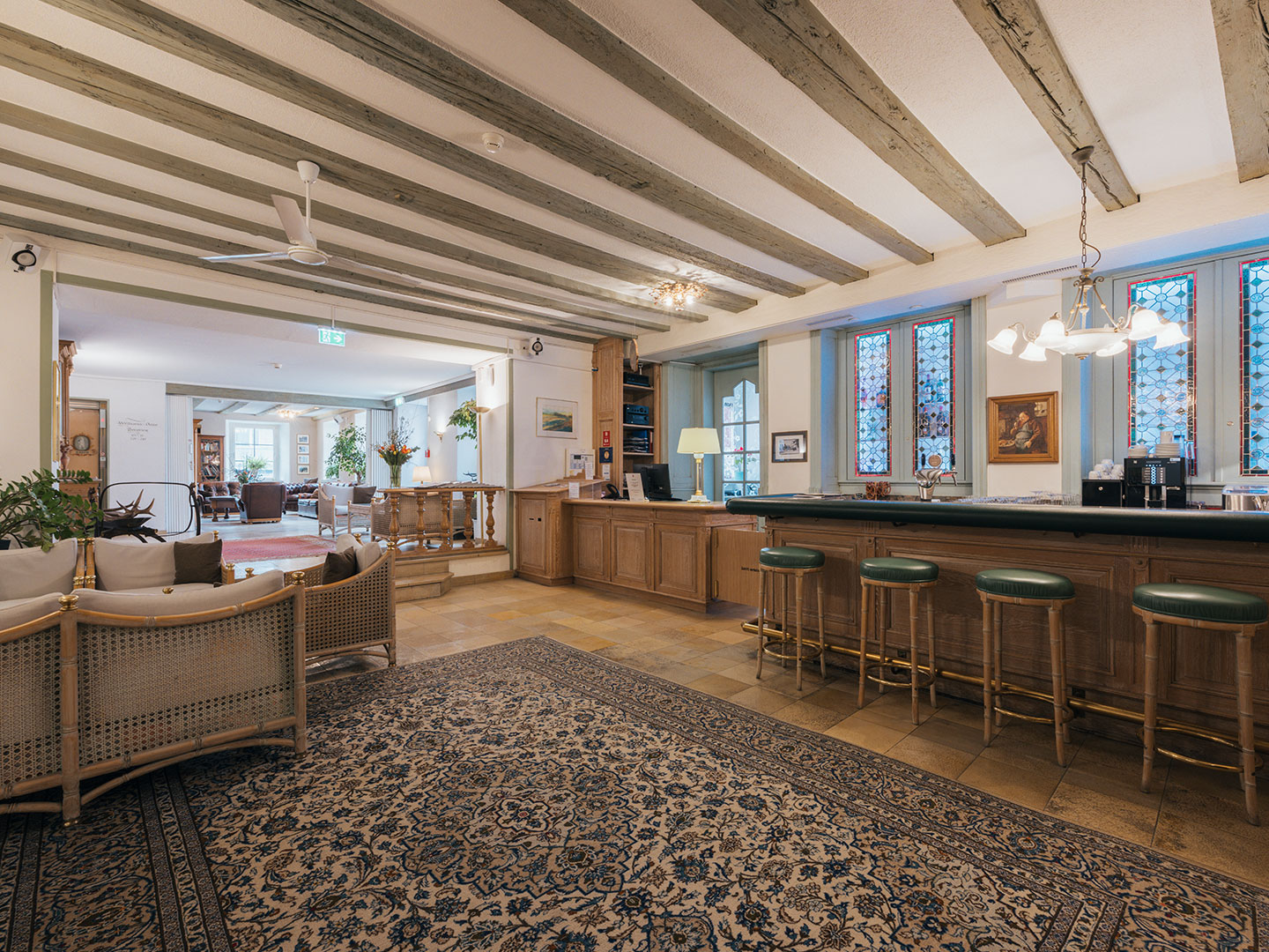 Lobby mit historischen Holzbalken und moderner Hotelbar im Hotel Bären Feldkirch